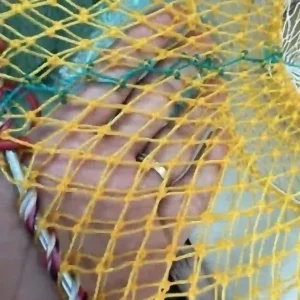Chi tiết phần viền của lồng bẫy cá màu vàng, được gia cố bằng dây thừng bện chắc chắn.