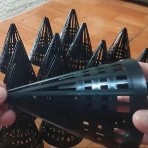 Một người đang cầm một chiếc hom nhựa, phía sau là rất nhiều hom nhựa khác được xếp ngay ngắn.