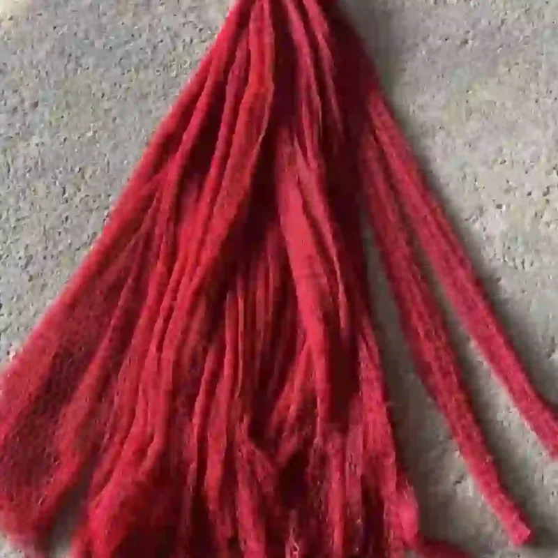 Một bó lưới tàng hình màu đỏ được để trên nền xi măng, cho thấy sản phẩm được bán theo bó hoặc theo mét.