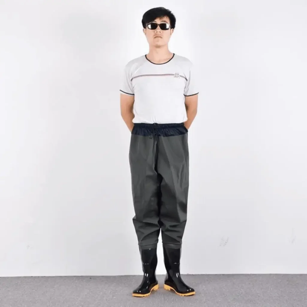 Người mẫu nam mặc quần lội nước liền ủng màu xám, ủng đen đế vàng.