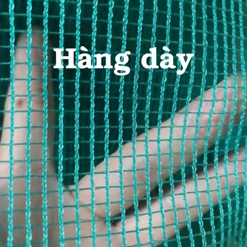 Cận cảnh tay cầm tấm lưới cước màu xanh loại dày, chất lượng cao, cho thấy rõ độ bền và các mắt lưới đều đặn.